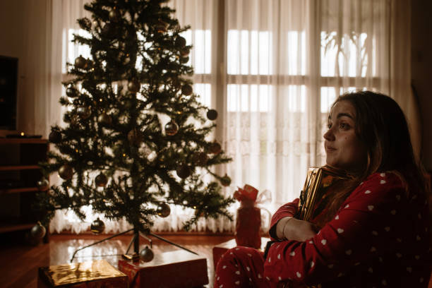 istock Young woman opening christmas presents 1282351683