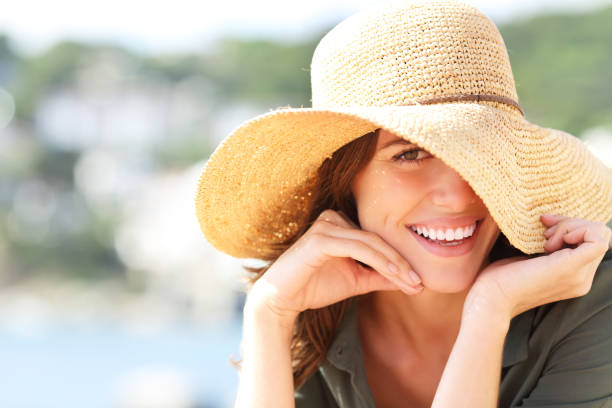 mujer feliz sonriendo con dientes perfectos en vacaciones - women summer hat beach fotografías e imágenes de stock