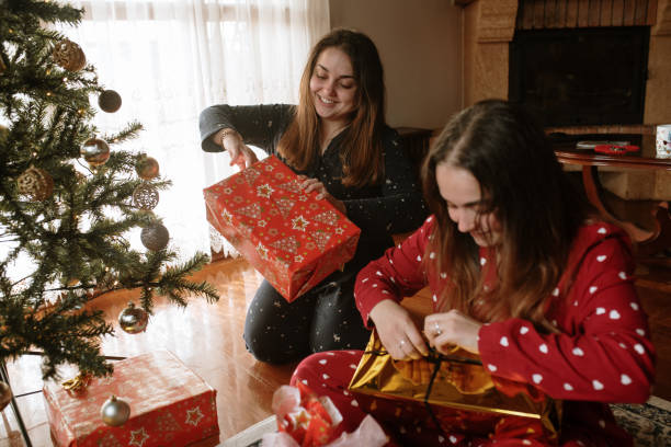 istock Young twin sisters opening christmas presents 1282353070