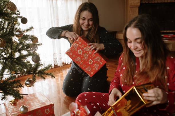 istock Young twin sisters opening christmas presents 1282353622