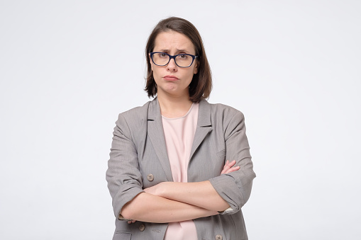 Skeptical mature woman in glasses wearing formal clothes looking suspicious. She does not trust her coworker. Negative human face expressions and emotions