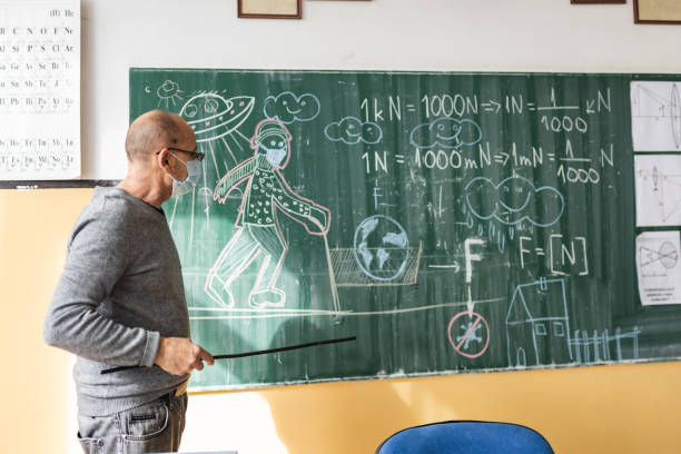 istock Professor teaching his students physics at the school in time of Coronavirus 1282361274