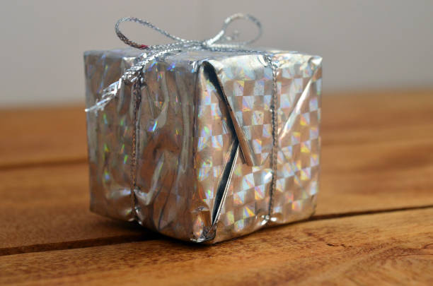 istock Silver colored Christmas gift on a light background. Donation. Scenery. 1282361609