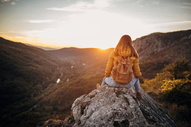 istock Woman sitting on mountain peak 1282362461