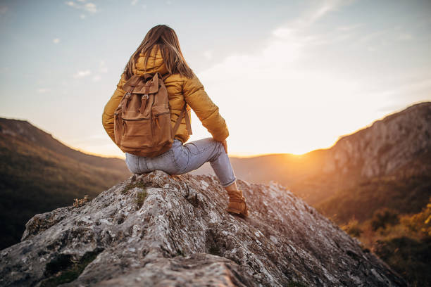 istock Woman sitting on mountain peak 1282362485