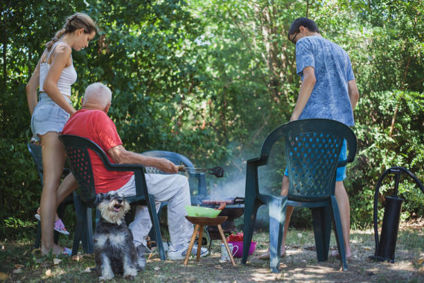Grandpa having fun with his grandson while eating barbecue sausages
