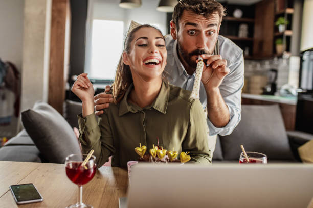 Couple celebrating birthday on a video call at home Couple is having a virtual birthday party at home during lockdown virtual birthday celebration stock pictures, royalty-free photos & images