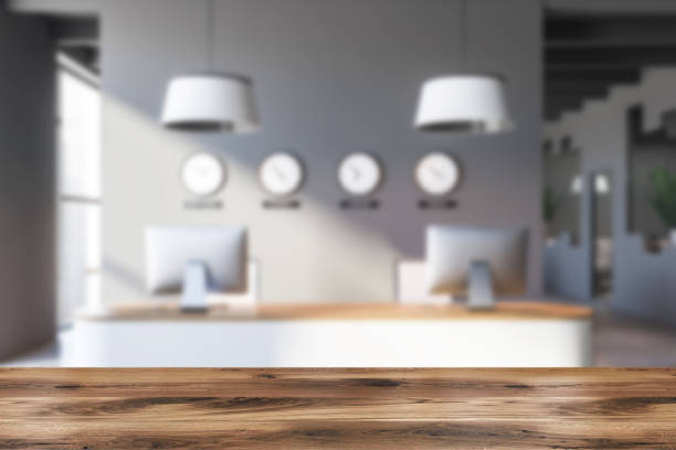 istock Table near reception desk with clocks in modern gray office lobby 1282368236