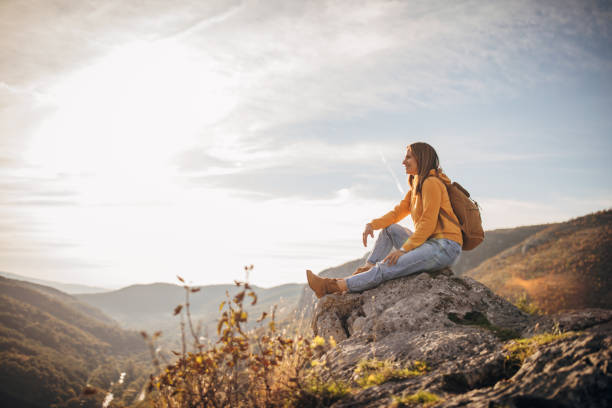 istock Woman sitting on mountain peak 1282369511