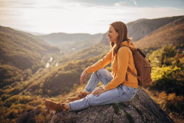 istock Woman sitting on mountain peak 1282370068
