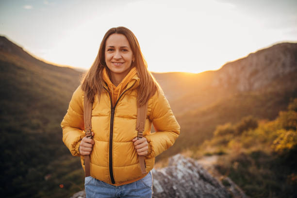 istock Woman hiker standing on mountain peak 1282370135