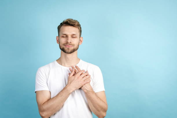 istock Smiling adult guy holding hands on chest 1282373216