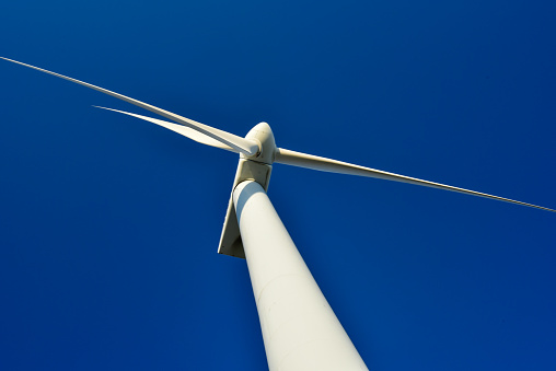 Generadores eólicos de torre en el telón de fondo de un cielo azul, para salvar el medio ambiente y ayudar a producir energía verde. photo