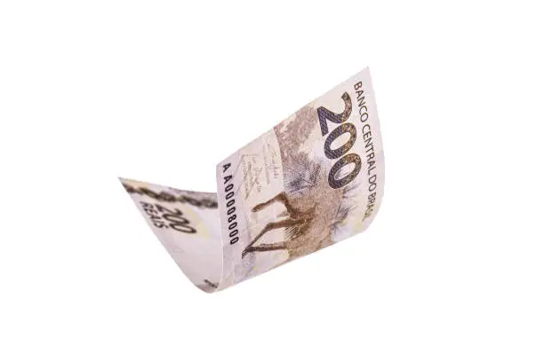 200 reais note falling, with selective focus. Two hundred reais from brazil isolated white background, money from brazil