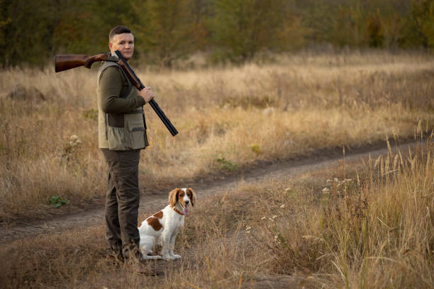 istock Hunter with Russian spaniel dog on the dirt road near forest. 1282376511