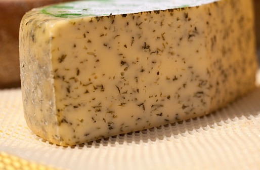 Assortment of cheese varieties on a wooden board. Side view, close-up.