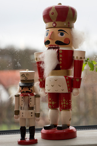 Traditional Christmas nutcracker wooden figure. Beautiful, festive toy soldier decoration, with copy space and tree lights bokeh in background.