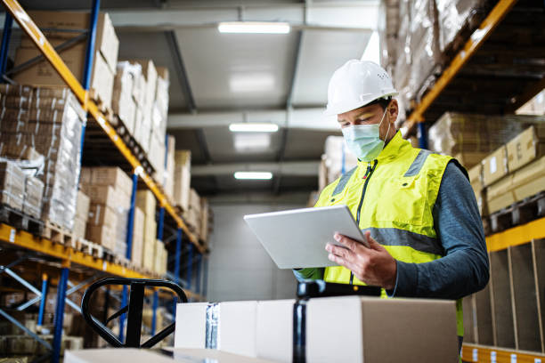 istock Man worker with tablet working indoors in warehouse, coronavirus concept. 1282377842