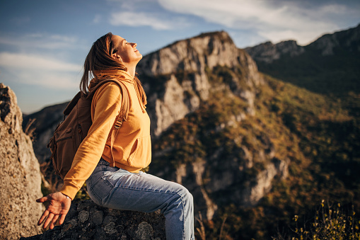 One woman, female hiker hiking alone on mountain, enjoying on mountain peak on sunny autumn day.