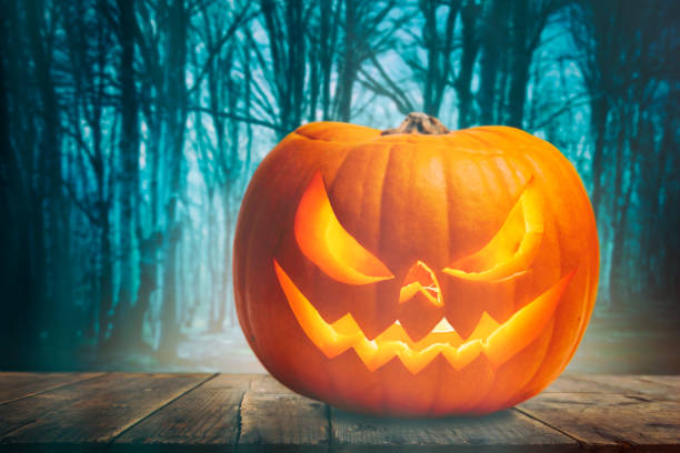 istock Pumpkin Burning In A Spooky Forest At Night - Halloween Background 1282379331