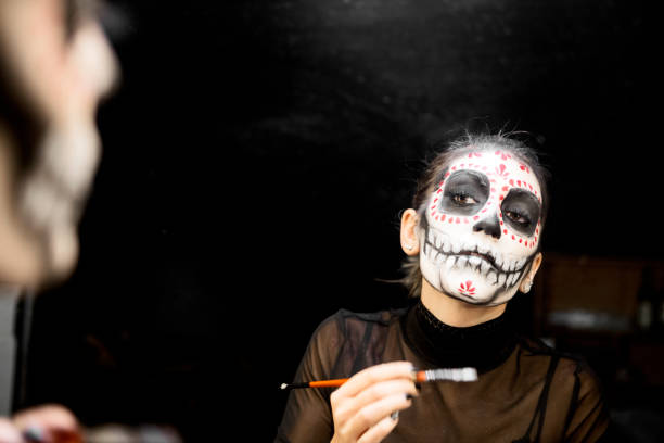 istock Face painting for Halloween night party looking at mirror getting ready looking at camera smiling 1282379358