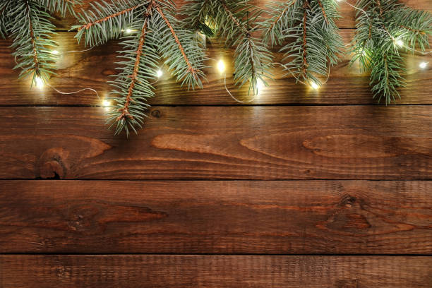 istock Christmas lights bulb and pine tree branches decoration on vintage wooden table. Merry Christmas and New Year holiday background. Flat lay, top view. 1282380337