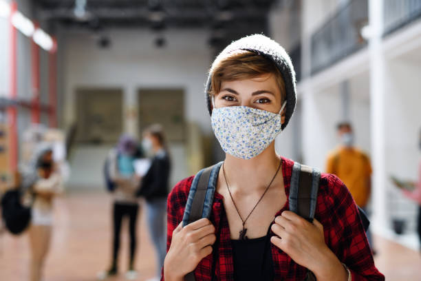 istock Young student with face mask back at college or university, coronavirus concept. 1282383654