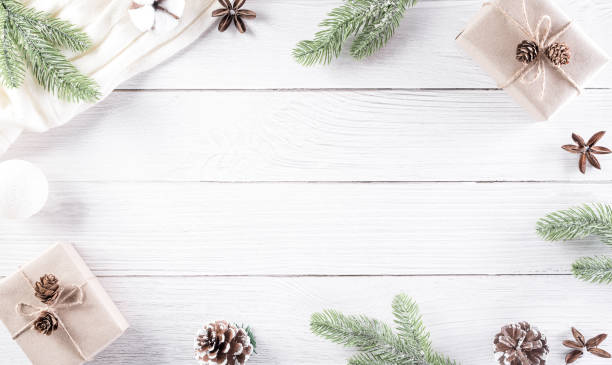 istock Christmas decor composition background. Christmas gift, pine cones, fir branches and sweater on wooden white background. Flat lay, top view with copy space. 1282384497