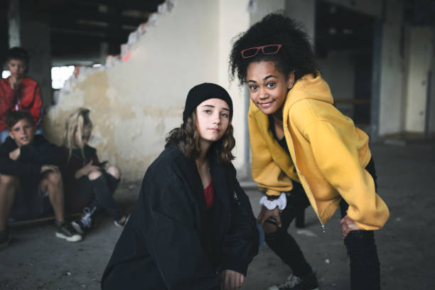 grupa nastolatków dziewczyna gang stoi w pomieszczeniach w opuszczonym budynku, wychodzić. - youth culture gang member adolescence family zdjęcia i obrazy z banku zdjęć