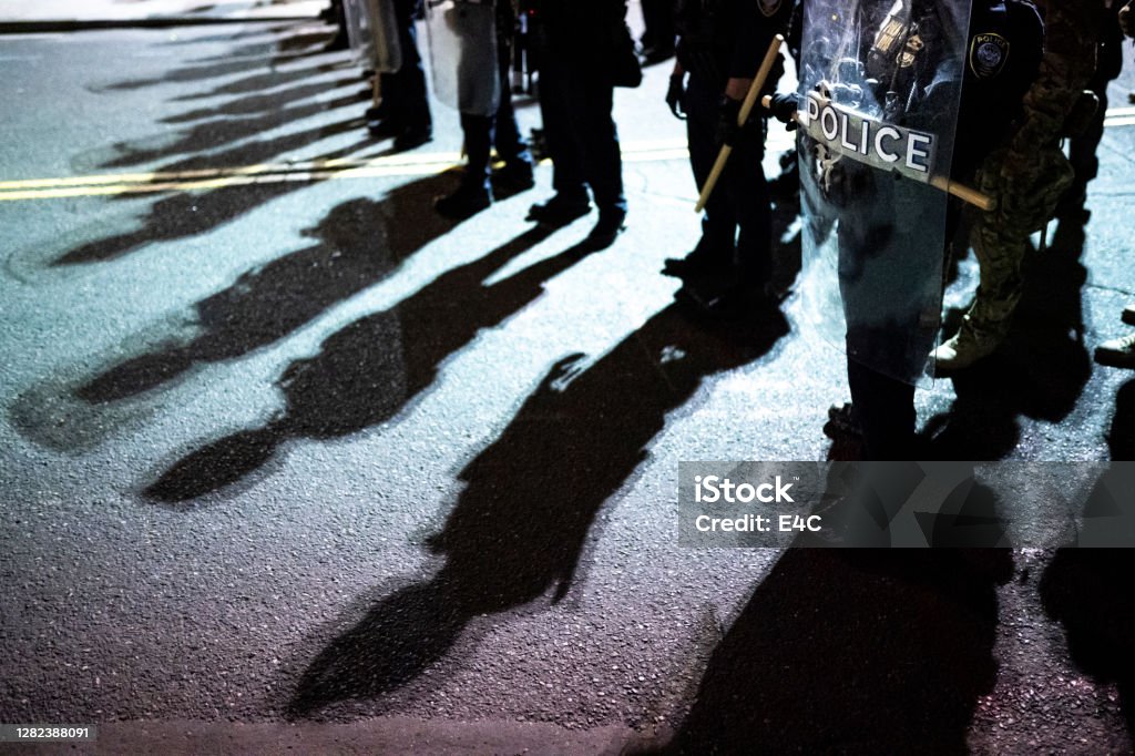 Police shields and shadows at activist protest Police Force Stock Photo