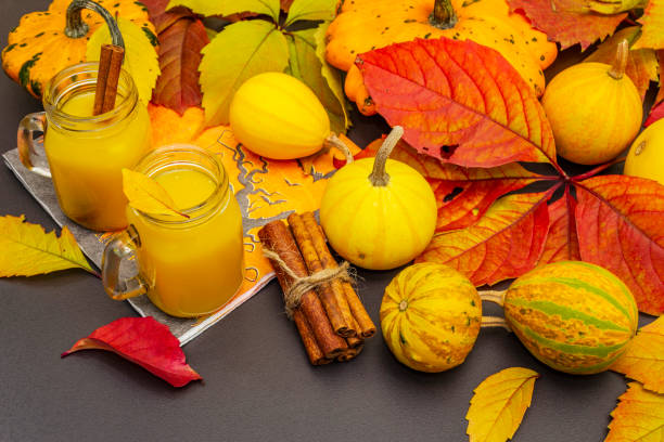 cóctel de naranja picante sin alcohol. bebida festiva de halloween, calabazas decorativas, hojas de otoño y palitos de canela - maple leaf close up symbol autumn fotografías e imágenes de stock