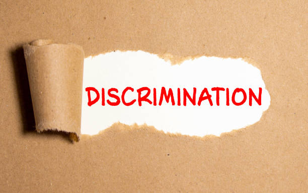 istock Discrimination is written on torn brown paper. Discrimination concept. 1282392619