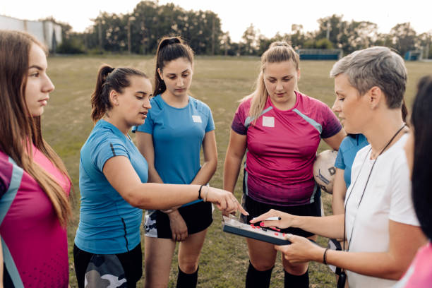 istock Girls from a rugby team making a play strategy with their coach 1282395315