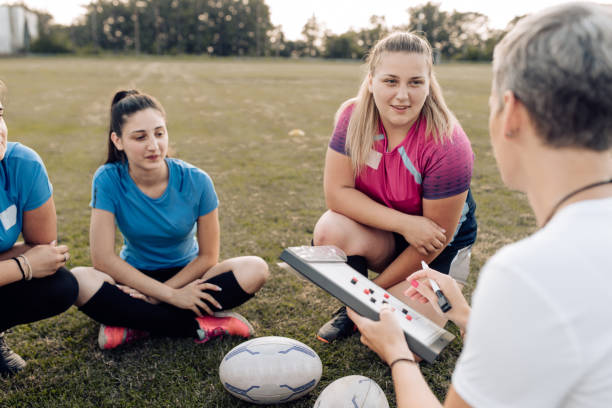istock Female rugby coach teaching her team play strategy 1282395318