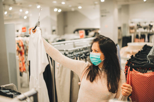 istock A young woman wears a protective mask while shopping at the Mall 1282395448