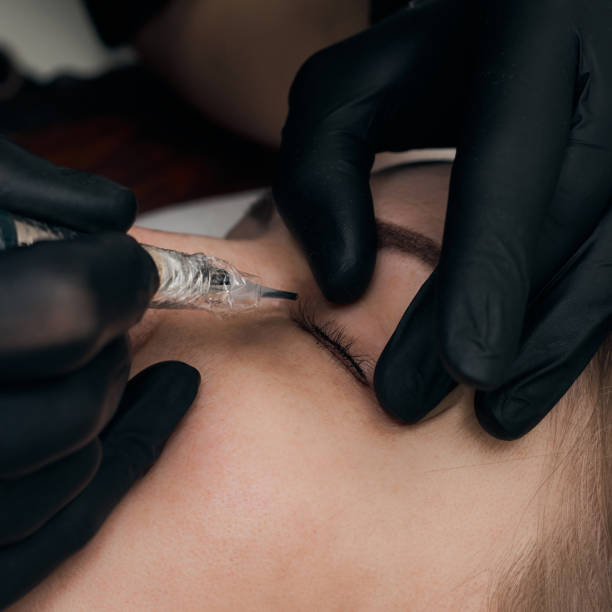 istock Permanent eyebrow makeup procedure. Eyebrow tattooing, process. The use of tools by a master for permanent eyebrow makeup. 1282395833