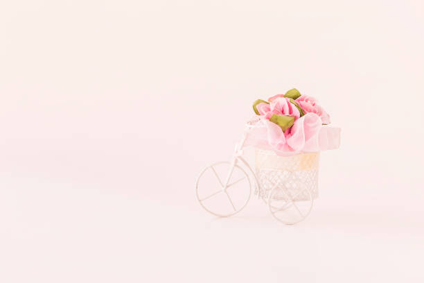 istock Pink rose paper flower on white bicycle 1282403648