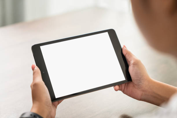 istock Young woman holding digital tablet with a blank screen on table, for putting advertising to promote. 1282406458