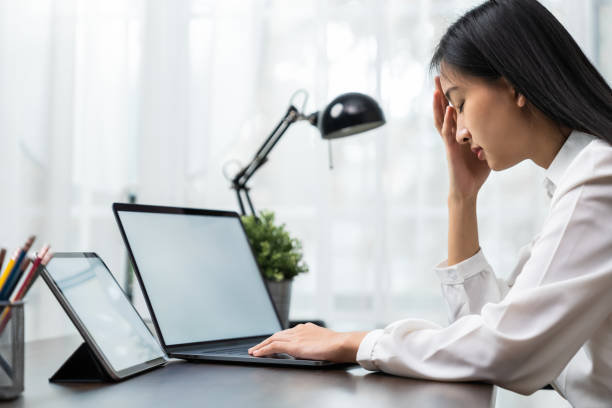 istock Asian business woman suffers from headache from working with computers for a long time. 1282406521