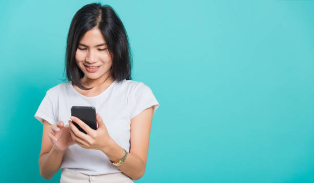 istock young woman standing smile holding using mobile smart phone 1282412629