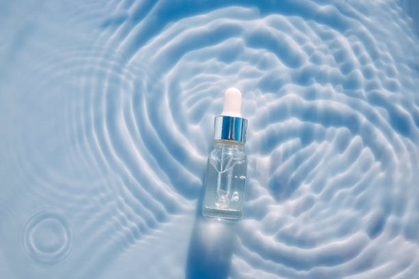 Medical spa cosmetics, serum on blue water texture background with splashes Cosmetic spa medical skin care, bottle for serum, micellar toner and emulsion on water texture background with splashes. Flat lay, copy space. blood serum photos stock pictures, royalty-free photos & images