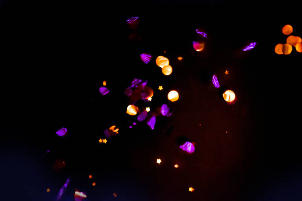 istock Abstract background, overlay of sparkling confetti in motion on black background 1282416964