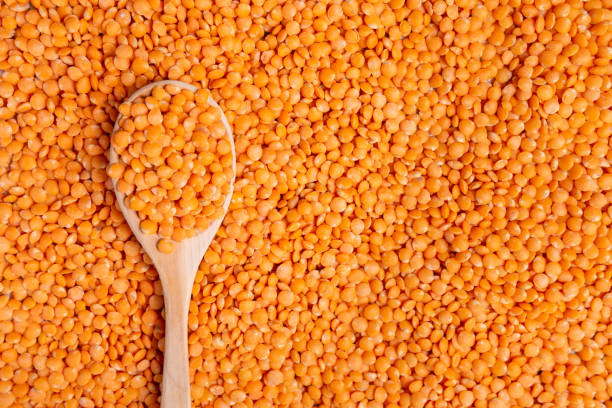 istock dry orange lentils in wooden spoons on top, flat lay. texture background 1282420480