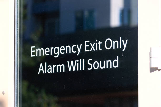 istock Emergency exit only, alarm will sound sign on the glass exit door leading to safety 1282421024