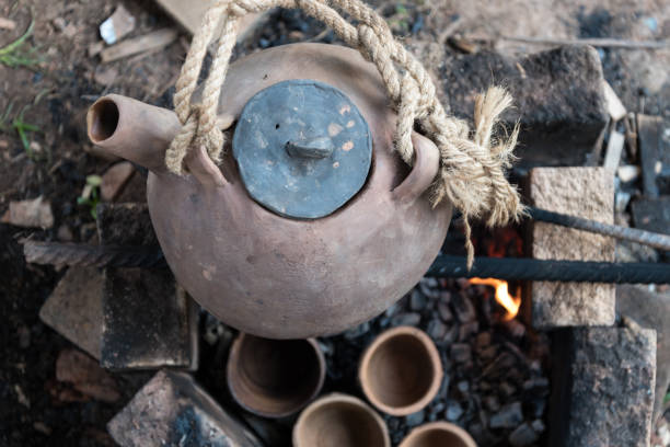 istock A steaming teapot and tea cups. Tea preparation in a clay pot on a fire. A camping trip, a journey. 1282425632