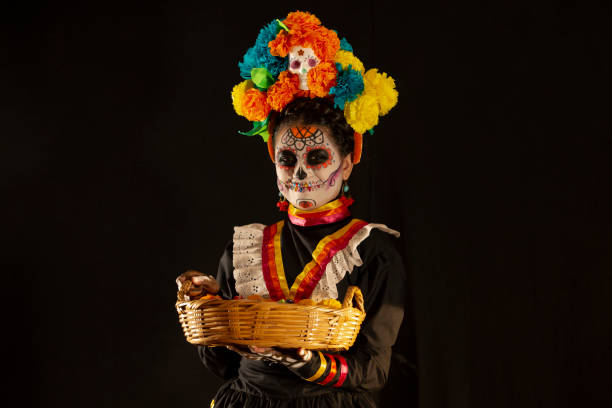 사탕, 땅콩, 오렌지, 간식을 제공하여 죽은 자의 날을 위해 두개골로 위장 한 라틴 소녀 - catrina 뉴스 사진 이미지