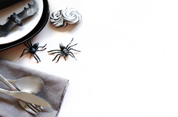хеллоуин стол настройки аксессуары: черная тарелка службы, белый салат пластины, серебряные столовые приборы и салфетки декоративных паук� - napking ring стоковые фото и изображения