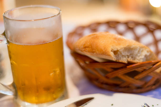 istock Cold draft lager beer in a glass mug,next to some partially eaten freshly made bread in a basket,Podgorica,Montenegro. 1282430761