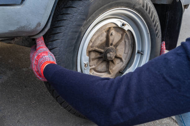 istock A woman removes a wheel on a car to replace it. 1282435609