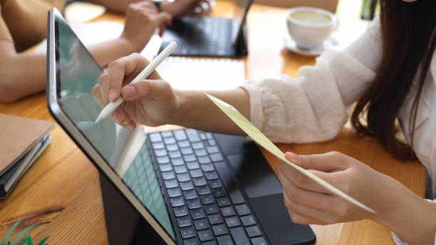 istock Cropped shot of female office worker writing on tablet while holding paper 1282436647